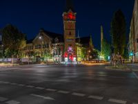 a night scene with traffic lights shining at an intersection with a church in the background