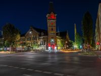 a night scene with traffic lights shining at an intersection with a church in the background