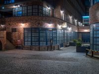 some dark blue windows in an industrial building with no one on the street to the right