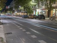 the street is empty as cars travel on the road at night and on the streets are busy