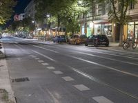 the street is empty as cars travel on the road at night and on the streets are busy