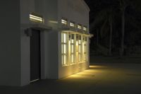 some light at the entrance to a building lit up for public use by outdoor lighting