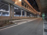 an empty street outside of an indoor car park at night by the waterline looking down