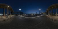 an intersection in a dark area with some cars at night, taken from a fisheye lens