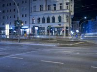 an intersection with a street scene at night in the city with traffic and lights, a few cars on the street