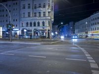 an intersection with a street scene at night in the city with traffic and lights, a few cars on the street