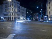 an intersection with a street scene at night in the city with traffic and lights, a few cars on the street