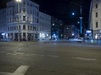 an intersection with a street scene at night in the city with traffic and lights, a few cars on the street