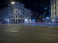 an intersection with a street scene at night in the city with traffic and lights, a few cars on the street