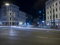 an intersection with a street scene at night in the city with traffic and lights, a few cars on the street