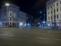 an intersection with a street scene at night in the city with traffic and lights, a few cars on the street
