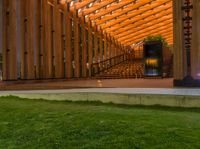 a wooden building with stairs and grass inside of it with lights on the top half