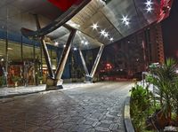 a view of a public walkway in the night with a fire hydrant and palm trees