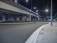 empty road lined with city lights on the sides of an overpass bridge with traffic