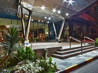 a hotel lobby, illuminated by street lights and some plants, near steps and railing