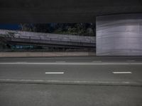 two lanes on road at night and a ramp in the background in black and white