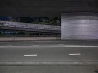 two lanes on road at night and a ramp in the background in black and white