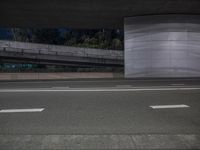 two lanes on road at night and a ramp in the background in black and white