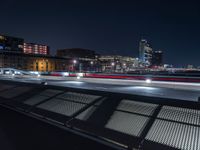 benches overlooking the night city skyline of a large city with skyscrapers behind them '