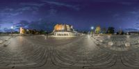 there is a very nice view from this fish eye shot at night time in a city square