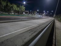 a view of a highway with multiple lanes at night with one car turning in opposite direction