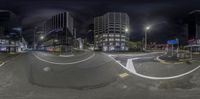 a street at night in front of tall buildings and skyscrapers with a circular picture of a person on a skateboard