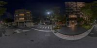 360 - view of city streets at night with lights on them, and people walking and bicycles parked in the foreground