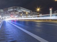 a city street lit up at night with long exposures of light from vehicles driving by