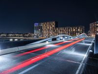 a bridge that goes across an empty road over a river at night at a marina