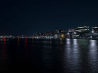 there are three buildings next to the water at night in this city setting on the river