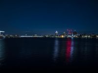 there are three buildings next to the water at night in this city setting on the river