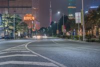 a city street with buildings and neon lights at night time in hong china as seen from an empty city highway