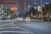 a city street with buildings and neon lights at night time in hong china as seen from an empty city highway