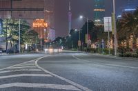 a city street with buildings and neon lights at night time in hong china as seen from an empty city highway