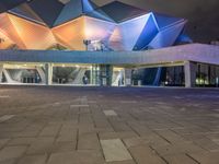 a building with three blue, white and purple lights on the side of it that appears to be an auditorium