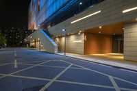 a street that has some steps down it by some building lights and a staircase on the side of the building