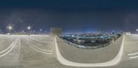 a circular shaped object shows a city at night time, and the reflection is of a skateboarder