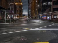 a road surrounded by buildings in the city at night time to depict the dangers of driving in