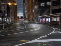 a road surrounded by buildings in the city at night time to depict the dangers of driving in