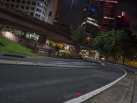 an empty street that is in front of tall buildings at night in a large city