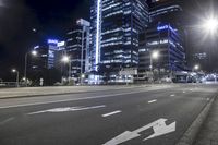 a street in a city with tall buildings lit up at night near a streetlight