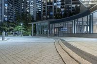 an empty sidewalk next to tall buildings in the city at night time as if for walking along them