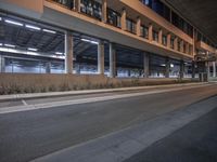 a street view in the middle of the night showing a parking garage and a bus station