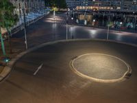 an intersection at night, with a boat in the background and some buildings on the other side