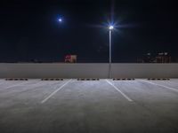 the parking lot has two parking spots underneath a street light at night with bright spotlights