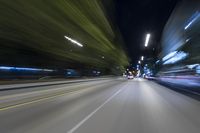 the photo shows the car driving through the city lights and traffic signs on the street