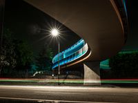 a car is driving underneath a bridge at night time on the street in this photo