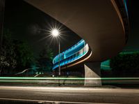 a car is driving underneath a bridge at night time on the street in this photo