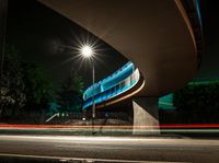 a car is driving underneath a bridge at night time on the street in this photo