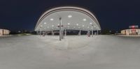 a gas station that is lit up at night with no one inside and the roof and pillars illuminated